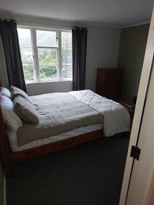 a bed in a bedroom with a window at The Peacock House in Wellington