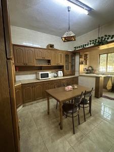 una cocina con mesa y sillas. en 3 Bedroom Family Apartment in Amman, en Amán