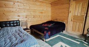 a bedroom with a bed in a wooden cabin at Family Guesthouse Bako in Bako