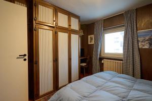 a bedroom with a large bed and a window at Casa Elena in Breuil-Cervinia