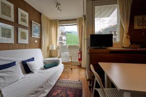 a living room with a couch and a table and a television at Casa Elena in Breuil-Cervinia