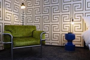una silla verde en una habitación con pared en Zámek Ostrolov, en Ostrolovský Újezd