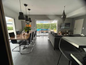 una sala de estar con una mesa y un sofá en Villa 5km du circuit 24h Le Mans, en Spay