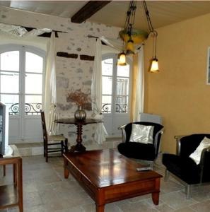 Hotel l'Oronge في سان جان دو جارد: غرفة معيشة مع طاولة قهوة وكراسي