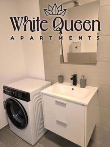 a white bathroom with a washing machine and a sink at White Quenn Apartments in Sanski most