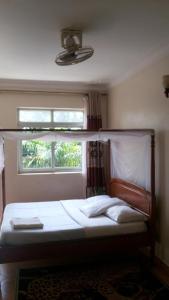 a bed in a bedroom with a window at ROSEVILLA HOTEL Limited in Arua