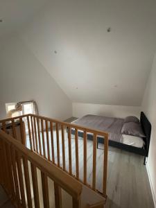 een slaapkamer met een bed en een houten trap bij Calme maison de campagne in Cressin-Rochefort +2 foto's