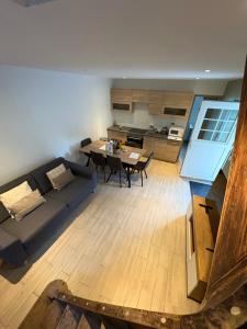 een woonkamer met een blauwe bank en een tafel bij Calme maison de campagne in Cressin-Rochefort