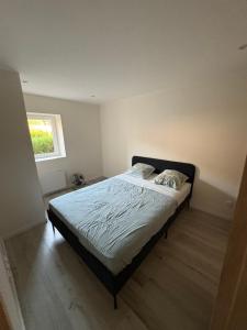 een slaapkamer met een bed in een kamer met een raam bij Calme maison de campagne in Cressin-Rochefort