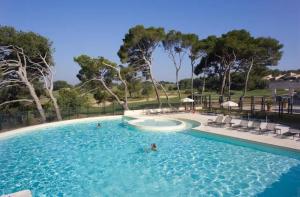 a swimming pool with people in the water at Appartement golf saumane Celomidie in Saumane-de-Vaucluse