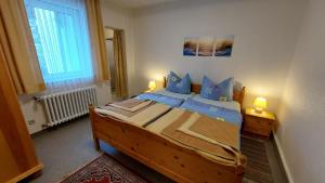 バート・ラウターベルクにあるFerienwohnung Weberのベッドルーム1室(大型木製ベッド1台、青い枕付) +1枚の写真
