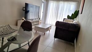 a living room with a glass table and a television at The Perfect Luxury Space at 93 on new in Midrand