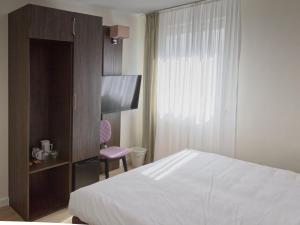 a hotel room with a bed and a chair at Fährhaus Hotel am Rhein by Mayburgh in Düsseldorf
