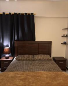 1 dormitorio con 1 cama con cortina negra en Musawir's Stay, en Hyderabad