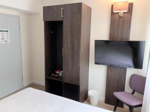 a hotel room with a tv and a bed at Fährhaus Hotel am Rhein by Mayburgh in Düsseldorf