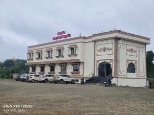 a building with cars parked in front of it at Hotel Nandi Resort in Jiwājīnagar
