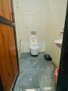 a small bathroom with a toilet and a sink at Hotel Nandi Resort in Jiwājīnagar
