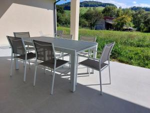 Une table à manger et des chaises sont disponibles sur la terrasse. dans l'établissement Modern Vosges Getaway, à Laveline