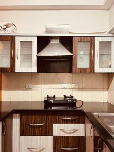 a kitchen with wooden cabinets and a stove at Springs Forever in Gachibowli