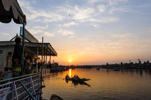 a group of people in boats on a river at sunset at Lakes and peaks in Srinagar
