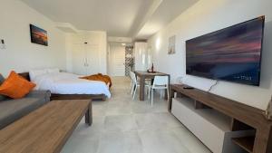 Zimmer mit einem Bett und einem großen Flachbild-TV in der Unterkunft BENALBEACH Vista al Mar in Benalmádena