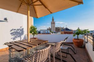 a table and chairs on a balcony with a view of the city at Joya del Casco Boutique Hotel by Shiadu in Seville