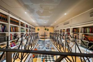 a library with a glass floor and bookshelves at Joya del Casco Boutique Hotel by Shiadu in Seville
