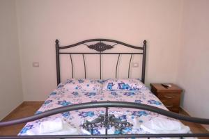 a bedroom with a bed with a floral bedspread at Nuovo Sun Golem in Golem +29 photos