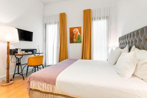 a bedroom with a bed and a desk with a computer at Joya del Casco Boutique Hotel by Shiadu in Seville +43 photos
