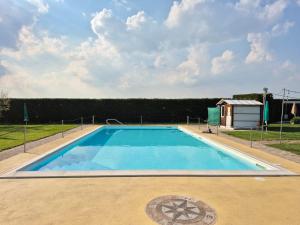 a large blue swimming pool with a building in the background at Agriturismo Trava in Portoverrara