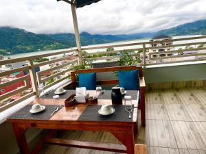 a table on a balcony with a view of the mountains at Novetel Boutique Home in Pokhara