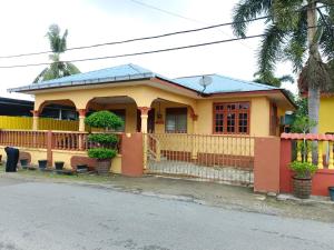 a yellow house with a fence in front of it at Addin Homestay Tanah Merah in Tanah Merah