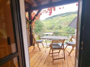 a table and chairs on a deck with a view at Casa Moselle-Royal Stilvoll Urlauben an der Mosel in Reil