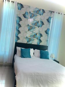 ein Schlafzimmer mit einem großen Bett mit blauem Kopfteil in der Unterkunft Shanty Town Homes in Kampala