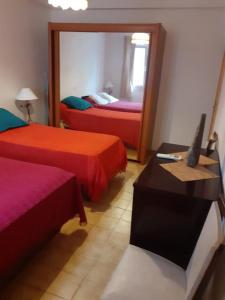 a hotel room with two beds and a mirror at Appartement T2 Alistro San Giuliano Corse in San-Giuliano