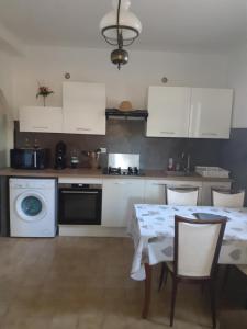 a kitchen with a table with chairs and a washing machine at Appartement T2 Alistro San Giuliano Corse in San-Giuliano +9 photos