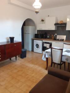 a kitchen with a table and a kitchen with a washing machine at Appartement T2 Alistro San Giuliano Corse in San-Giuliano