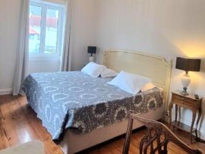 una camera da letto con un letto con un piumone blu e una finestra di Valentina's House a Porto da Cruz