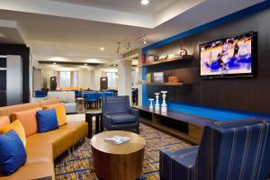 a living room with a couch and a flat screen tv at Courtyard St. Louis Airport/Earth City in Bridgeton