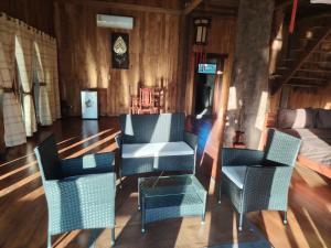 une chambre avec des chaises, une table et un lit dans l'établissement Nirvana Archipel Resort, à Vang Vieng