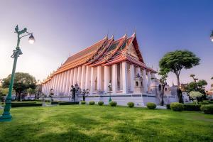 un grand bâtiment blanc avec un toit pointu dans l'établissement The Hidden Sao Chingcha - ถนนดินสอ xPro, à Bangkok