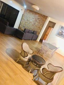a living room with a table and chairs and a couch at Hotel le Mbosse in Niaga