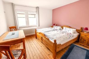 a bedroom with a wooden bed and a table at Ferienhaus Franziska in Münstermaifeld