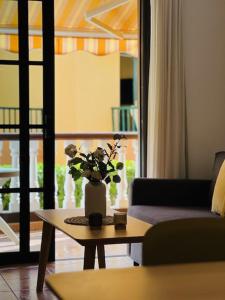 a living room with a table with a vase of flowers on it at Holiday in Playa Calera - Swimming pool in Valle Gran Rey