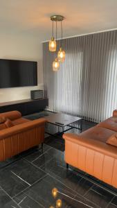 a living room with two couches and a tv at La Maison 91 in Croix-en-Ternoise