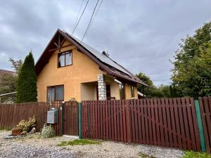 a house with a fence in front of it at Kata Home by RentALL in Gheorgheni