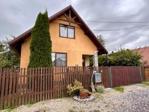 a house with a wooden fence in front of it at Kata Home by RentALL in Gheorgheni