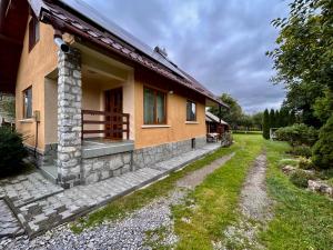 a house with a pathway next to a building at Kata Home by RentALL in Gheorgheni +10 photos