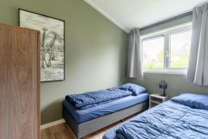 a bedroom with two beds and a picture of a giraffe at Nieuw! 6-persoons chalet aan het Veluwemeer dichtbij Harderwijk, Amersfoort en Zwolle in Hulshorst