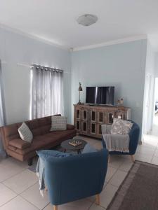 a living room with a couch and two chairs at The Pebble Garden Swakopmund in Swakopmund +1 photo